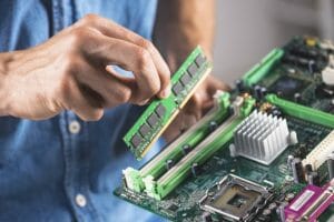 pc pitstop technician putting ram memory module into computer motherboard