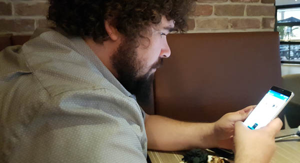 Man at table looking at mobile phone