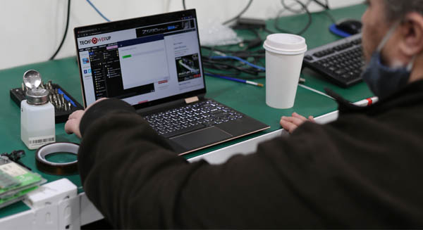 technician installing software onto repaired laptop