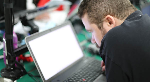 computer technician upgrading hard drive to SSD on a laptop